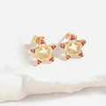 Macro shot of gold star stud earrings with red and yellow enamel on white marble background - Pentagram / Gold Red Star