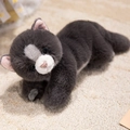 Peluche gatto persiano grigio scuro in posizione sdraiata con dettagli bianchi e pelo morbido - grigio scuro
