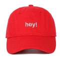 Détail d'une casquette en coton rouge avec broderie 'hey!' blanche et coutures fines - Réglable / Rouge