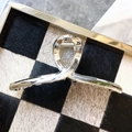 Detail of silver metallic twisted hair claw clip on checkered faux fur tray display - Twisted Shape (5)