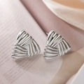 Strukturierte silberne Dreiecksohrstecker für Damen auf rosa und beigem Stoffhintergrund - Strukturiertes Design / Silber Dreieck