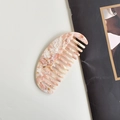 Pink acetate hair comb with marble pattern texture on a clean white background - Apricot Oval