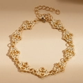 Detailed close-up of hollow heart-shaped links on a vintage gold bracelet with lobster clasp - Gold