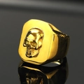 Macro shot of gold skull ring with high-gloss finish and reflection on black surface - US 7 / Gold
