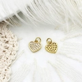 Macro view of gold heart pendants with micro-pave crystals on soft feather background - Heart
