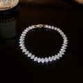 Vue macro d'un bracelet argenté avec pierres marquises sur fond noir brillant de luxe - Incrustation Complète en Marquise