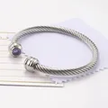 Bracciale rigido aperto a treccia argento con due pietre di zircone viola scintillanti - Febbraio/Viola
