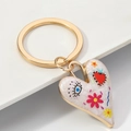 Golden heart keychain with white enamel, featuring blue eye and colorful flower patterns - Style F