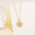 Makro-Detail des goldenen Evil Eye Anhängers mit Zirkonia auf weißem Ständer - Gold