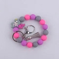 Dettaglio del braccialetto in silicone rosa e viola con ciondolo a sirena grigio e anello - Grigio