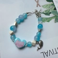 Handmade beaded bracelet in blue tones with cartoon pig charm and silver fishtail pendant - Heart Pig - Blue