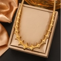 Detailed macro view of a gold spiral spring link necklace on a jewelry display box - Gold