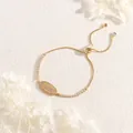 Détail d'un bracelet LOVE doré ajustable avec zircons étincelants sur fond de pierre - Style de Lettre LOVE (BR1763-A) / Doré