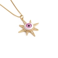 Détail macro du collier doré avec pendentif œil porte-bonheur et iris rose serti - boîte chaîne / Mauvais Œil Rose