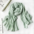 Light green cotton linen scarf with pleated texture and tassel edge on striped background - 1477 Modal Bean Green
