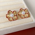 Detailed view of red flower earrings with gold petals and white pearls in a jewelry box - Pleated Pearl Flower Style