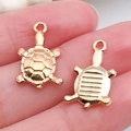 Handheld display of two gold turtle alloy charms for DIY jewelry and necklaces - Sea Turtle Pendant 11x18mm