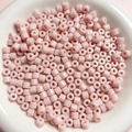 Vista macro di perline acriliche rosa cilindriche da 6 mm per gioielli in una ciotola - Rosa Chiaro