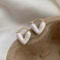 Detailed macro view of heart-shaped pearlescent earrings with elegant gold metal clips - White V-Shape Drip Oil