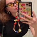 Detailed view of colorful Y2K beaded phone strap with red heart charms on a phone - Rainbow Heart Acrylic