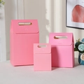 Detailed view of pink kraft paper gift bags in three different sizes with handles - Pink