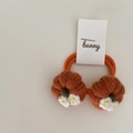 Pair of knitted pumpkin hair ties with white flower detail on a clean white surface - Orange Pumpkin