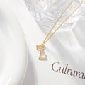Close-up of gold letter L pendant necklace with zircon flower detail on a white background - Letter Z