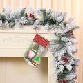 Detail of Christmas stocking featuring a faceless gnome doll and festive pine cone garland - Light Green