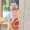 Close-up of pink plastic sports bottle showing straw, calorie print, and water scale marks - Pink