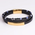 Detalle de pulsera de cuero multicapa con cuentas azules, dije de cruz y cierre magnético - Dorado