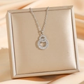 Elegante Halskette mit doppelter Schlaufe und Baguette-Diamanten auf einer Schmuckbox - Vollbesetzter Achter / Silber