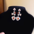 Vue détaillée des boucles d'oreilles fleurs argentées avec pierres orange sur support - Boucles d'oreilles tridimensionnelles en pierres précieuses et fleurs (7#) / Argent/Marron