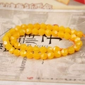 Nahaufnahme von facettierten gelben Achatperlen für DIY-Schmuck auf Vintage-Papiergrund - 8mm / Gelb