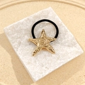 Golden starfish hair tie with textured stainless steel charm on elastic black band - Spiral Starfish Hair Tie