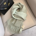Soft light green wool scarf with fringe detail draped elegantly on a leather sofa - Bean Green