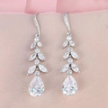 Elegante lange Quasten-Ohrringe in Blattform mit Zirkonia-Tropfen auf Textilhintergrund - Blatt Wassertropfen Quaste Anhänger / Weißgold