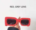 Detail view of bold red square sunglasses frame with dark gray protective lenses - Red Frame Gray Lens