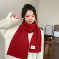 Thick red knitted scarf with white brand label simpomi worn over a white sweater - Approx. 160cm / Red