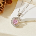 Gros plan d'un collier lune argenté avec un pendentif en cristal rose en forme de cœur - Style Lune Cœur Zircon Rose Argenté (T011)