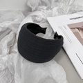 Close-up of black textured fabric headband with pleats on aesthetic magazine background - Gray