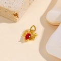 Détail d'un pendentif araignée doré serti d'une pierre rouge sur base de pierre - Rouge