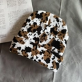 Close-up of the thick knit texture on a black and white cow pattern beanie hat - One Size / Large Leopard Print