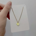 Detailed view of a gold titanium steel leaf and heart pendant on a minimalist chain - DN111 Shield Heart