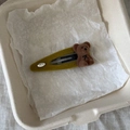 Primer plano de la horquilla flocada verde oliva con osito de peluche y placa Love plateada - Pieza Única / Verde