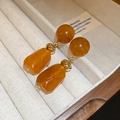 Close-up of vintage U-shaped amber resin earrings with gold plating in a jewelry box - 34# Silver Earring Post-Brown-Faceted Geometric Pendant