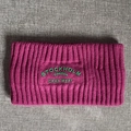 Details des lila Strick-Stirnbands mit grünem geprägtem Stockholm Sweden-Schriftzug - Kastanienrot