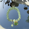 Green crystal beaded bracelet featuring a gold Ruyi lock charm on a reflective mirror - S048-green Peace Lock Donglin Jade Beaded Bracelet #sz352
