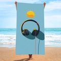 Blue microfiber beach towel featuring modern headphone and sun graphic held by a model - B76-Headphones and Sun Pattern