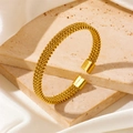Macro detail of gold woven mesh texture and square end cap on the open cuff bracelet - Gold