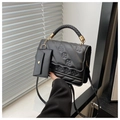 Details einer schwarzen PU-Lederhandtasche mit Webgriff und goldfarbenen Beschlägen - Schwarz